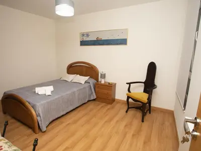 a bedroom with a bed and a chair at VIVAVI piso in Sarria