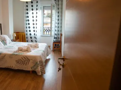 a bedroom with a bed and a large door at VIVAVI piso in Sarria
