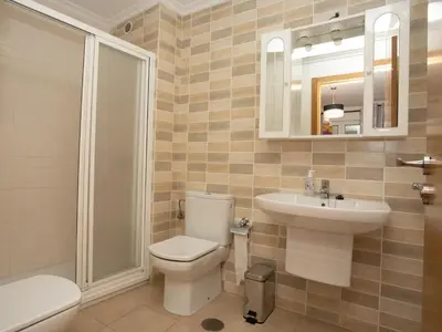 a bathroom with a toilet and a sink and a mirror at VIVAVI piso in Sarria