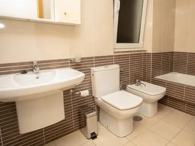 a bathroom with a toilet and a sink and a tub at VIVAVI piso in Sarria