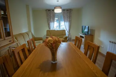 a living room with a table with a vase of flowers on it at VIVAVI piso in Sarria