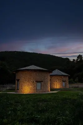 a stone building in a field with a mountain in the background at Pallozas Turisticas Ridicodias - A Pedra in Matamá