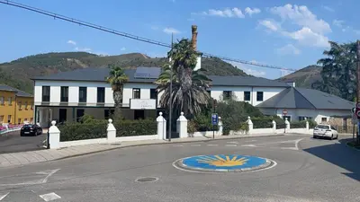 a street with a building and a building with a sun on the road at Viña Femita in Villafranca del Bierzo