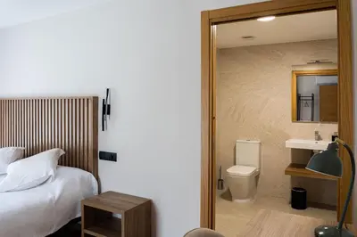 a bedroom with a bed and a sink and a mirror at Viña Femita in Villafranca del Bierzo