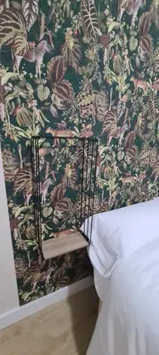 a bedroom with a wall with a floral wallpaper at Casita del Río Ourense in Ourense