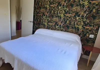 a bedroom with a white bed with a wallpaper at Casita del Río Ourense in Ourense