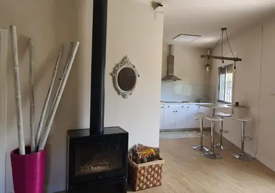 a living room with a fireplace and a kitchen at Casita del Río Ourense in Ourense