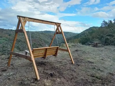 a swing in a field with a picnic table at Casita del Río Ourense in Ourense