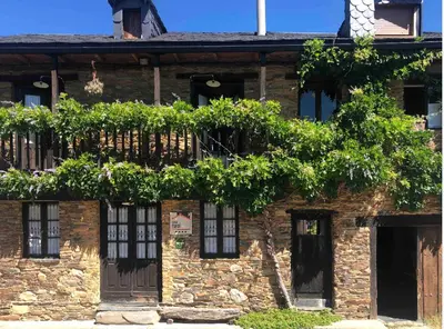 a brick building with windows and plants on it at Casa rural **** El Barreiro. Ideal para familias. in Sorbeda