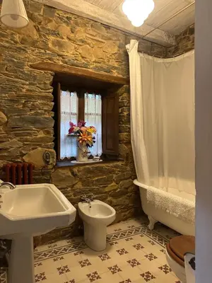 a bathroom with a sink and a tub and a toilet at Casa rural **** El Barreiro. Ideal para familias. in Sorbeda