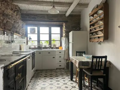 a kitchen with a refrigerator and a table with chairs at Casa rural **** El Barreiro. Ideal para familias. in Sorbeda