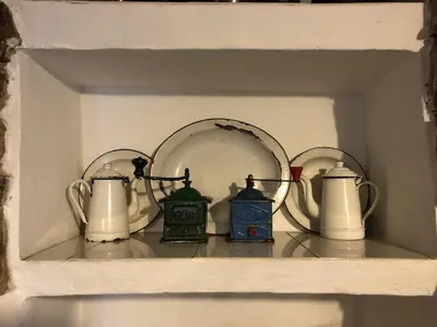 a shelf with tea pots and clocks on it at Casa rural **** El Barreiro. Ideal para familias. in Sorbeda