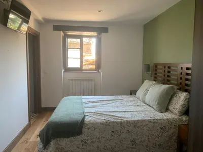 a bedroom with a large bed with a window at PiluPeta Casa de Aldea in Goje