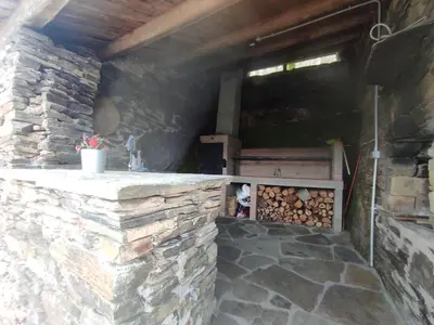 an outdoor kitchen with a stone wall at PiluPeta Casa de Aldea in Goje
