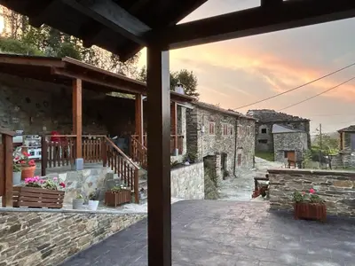 an outside view of a stone building with a patio at PiluPeta Casa de Aldea in Goje