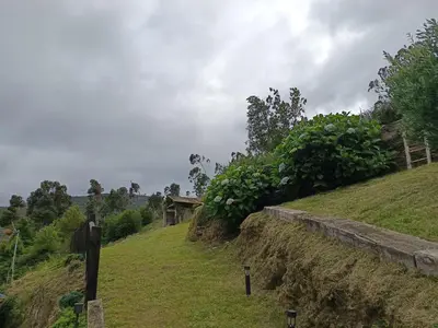 a grassy hill with a building on top of it at PiluPeta Casa de Aldea in Goje