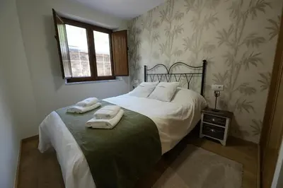 a bedroom with a bed with two towels on it at Vivienda Uso Turístico As Quintas in Suarbol