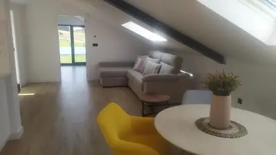 a living room with a table and yellow chairs at POLAS BEACH LOFT in Nois