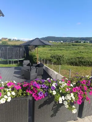 a patio with flowers and an umbrella in a field at POLAS BEACH LOFT in Nois