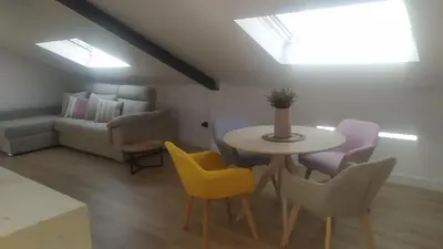 a living room with a table and chairs and a couch at POLAS BEACH LOFT in Nois