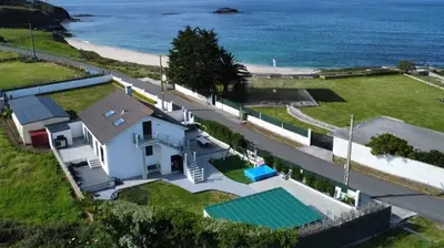 an aerial view of a house with a swimming pool and the ocean at POLAS BEACH LOFT in Nois