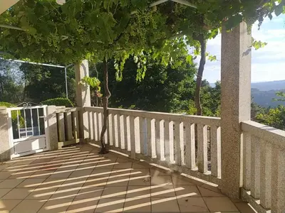 a room with a chair and a table and windows at Casa do Cuco, Ribeira Sacra in Ourense