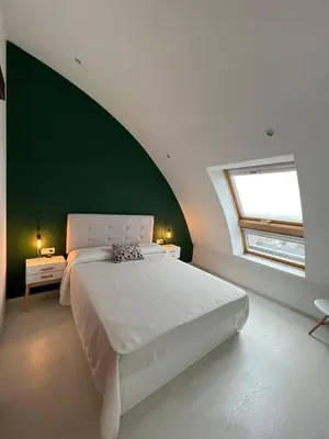 a bedroom with a large bed and a green wall at BALCÓN DO MARIÑEIRO in Burela de Cabo