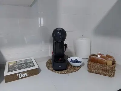 a black blender sitting on a counter with a basket of bread at Hostel & Rooms Casa Maia in Padrón