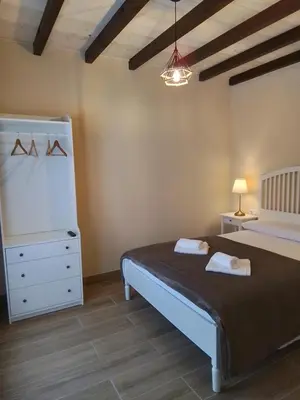 a bedroom with a bed and a dresser and a lamp at Hostel & Rooms Casa Maia in Padrón