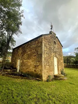 an old stone building with a cross on top of it at Casa Grande de Láncara in Lugo