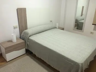a small bedroom with a bed and a mirror at Apartamento Centrico y Tranquilo El Rinconcito in Ourense