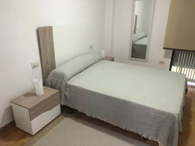 a small bedroom with a bed and a mirror at Apartamento Centrico y Tranquilo El Rinconcito in Ourense