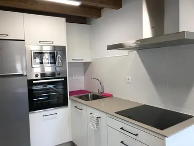 a white kitchen with a sink and a stove at Casa Cea in Melide