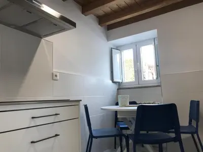 a kitchen with a table and chairs and a window at Casa Cea in Melide