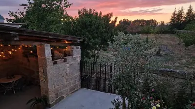 a patio with a fence and a table with lights at Casa da Penela in Nogueira de Ramuin