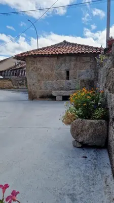 a stone building with flowers in front of it at Casa da Penela in Nogueira de Ramuin