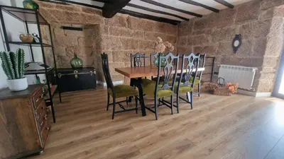 a dining room with a wooden table and chairs at Casa da Penela in Nogueira de Ramuin