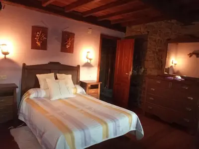 a bedroom with a bed and a dresser and lights at CASA CHANOS in Cangas del Narcea