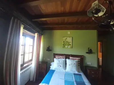 a bedroom with a bed and a window at CASA CHANOS in Cangas del Narcea