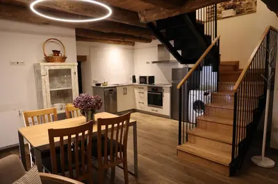 a kitchen and dining room with a table and stairs at Casa Os Prados da Albela in Tríacastela