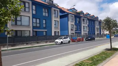 a white car parked in front of a row of buildings at ÁTICO 2 terrazas LEMASALUD in Ares