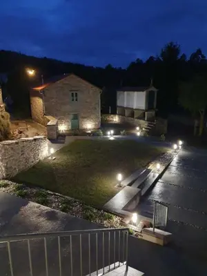 a house with lights in a yard at night at A Casa Do Boi in Amés