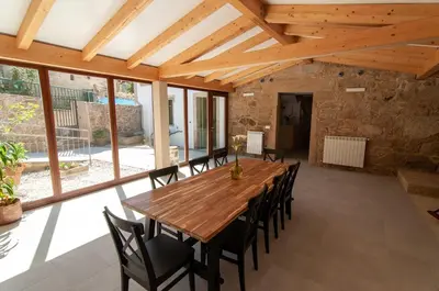 a large dining room with a wooden table and chairs at A Casa Do Boi in Amés