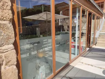 a store window with a reflection of a clock in it at A Casa Do Boi in Amés