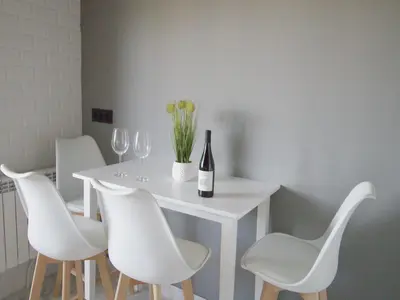 a white table with white chairs and a bottle of wine at CASA MIRADOR REZA Alojamiento Termas in Ourense