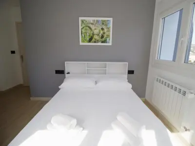 a white bed in a room with a window at CASA MIRADOR REZA Alojamiento Termas in Ourense
