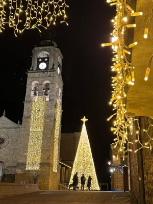 a clock tower with a christmas tree in front of it at Casa Tía Milagros in Puebla de Sanabria