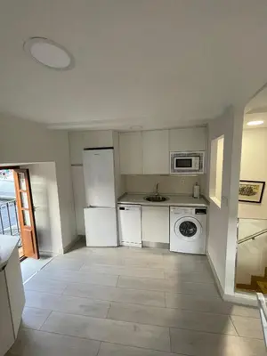 a kitchen with white appliances and a tile floor at Casa Tía Milagros in Puebla de Sanabria