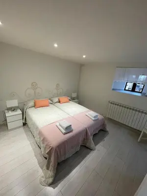 a bedroom with a large bed and a window at Casa Tía Milagros in Puebla de Sanabria