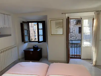 a bedroom with a bed and a door to a balcony at Casa Tía Milagros in Puebla de Sanabria